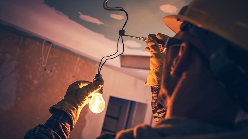 Electrician wiring a lighting fixture
